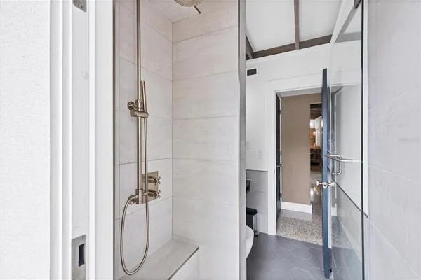 a bathroom with a sink a toilet a mirror and shower