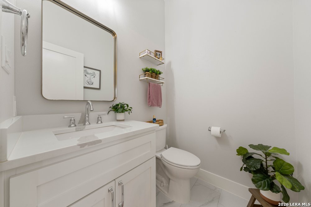 116 Park Heights Poth, TX 78147 - Photo 22 of 48 a bathroom with a granite countertop toilet a sink and mirror