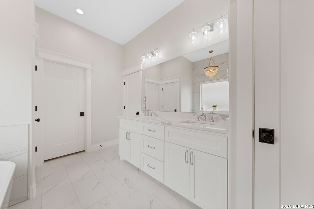 116 Park Heights Poth, TX 78147 - Photo 30 of 48 a bathroom with a double vanity sink and mirror with shower