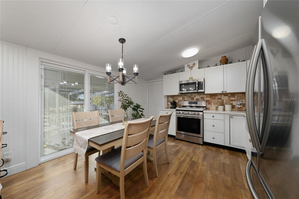 708 Fazzini Road Babson Park, FL 33827 - Photo 12 of 47 a kitchen with a refrigerator a stove a sink dishwasher a dining table and chairs with wooden floor