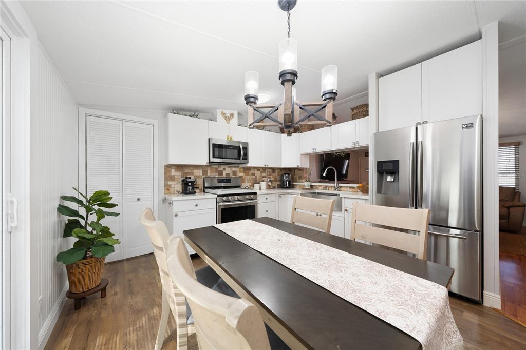 708 Fazzini Road Babson Park, FL 33827 - Photo 16 of 47 a kitchen with granite countertop a refrigerator a stove a sink dishwasher and white cabinets with wooden floor