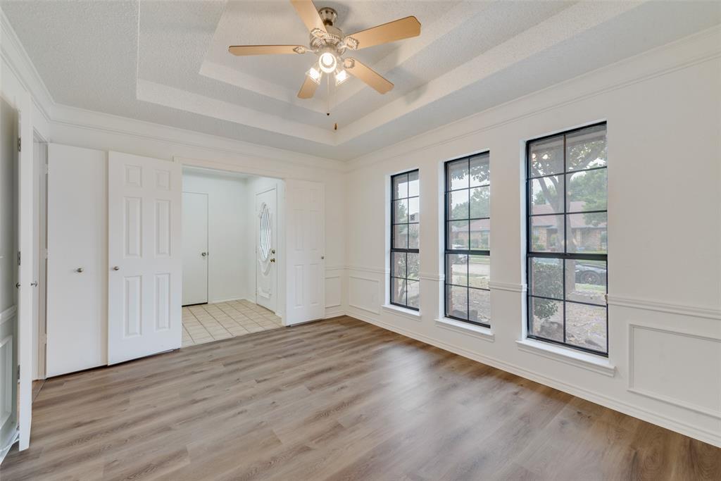 208 Timber Ridge Drive Murphy, TX 75094 - Photo 11 of 22 an empty room with wooden floor fan and windows