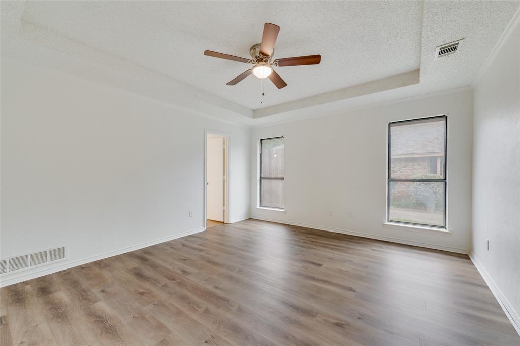 208 Timber Ridge Drive Murphy, TX 75094 - Photo 17 of 22 an empty room with wooden floor ceiling fan and windows
