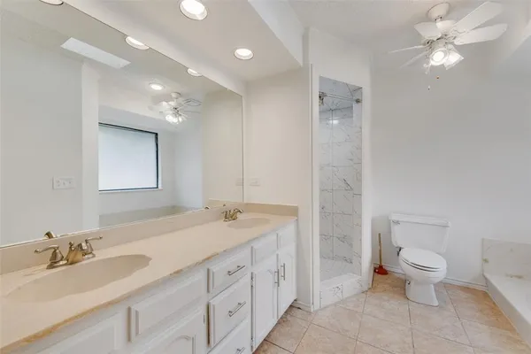 a spacious bathroom with a granite countertop sink a toilet and a mirror
