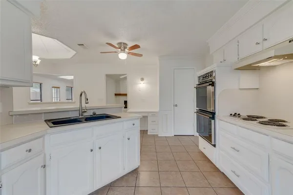 a kitchen with granite countertop a stove a sink and a refrigerator