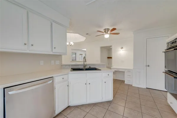 a kitchen with white cabinets appliances and a sink