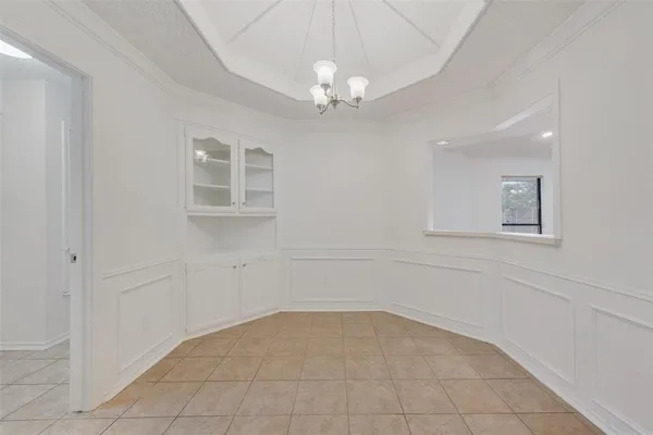 en empty room with windows and chandelier fan