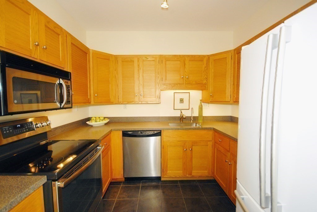 100 Keyes Road, Unit 307 Concord, MA 01742 - Photo 11 of 32 a kitchen with a sink a stove and cabinets
