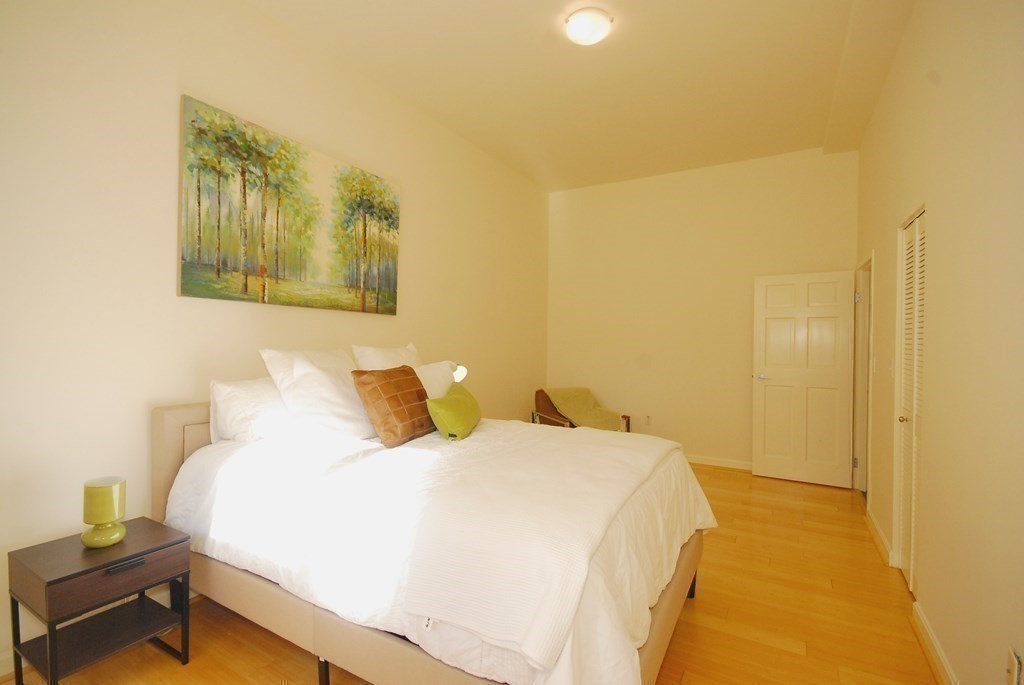 100 Keyes Road, Unit 307 Concord, MA 01742 - Photo 17 of 32 a bedroom with a bed and wooden floor