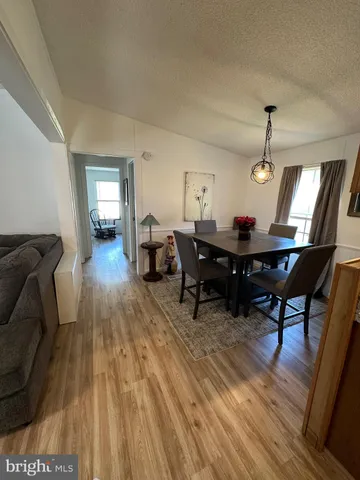 a living room with furniture a dining table and wooden floor