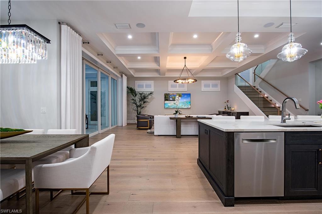 6830 Mangrove Avenue Naples, FL 34109 - Photo 12 of 28 a kitchen with stainless steel appliances kitchen island a large island in the center a sink a window and chairs
