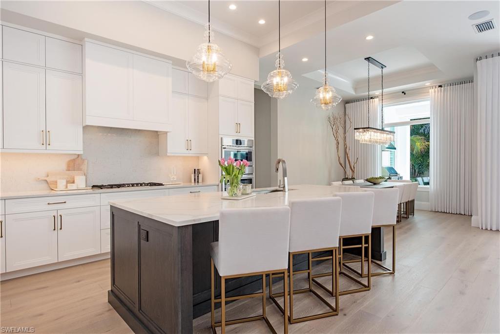 6830 Mangrove Avenue Naples, FL 34109 - Photo 13 of 28 a kitchen with kitchen island a dining table chairs sink and cabinets