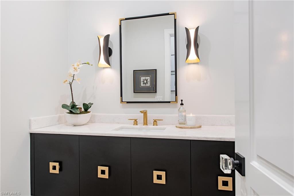 6830 Mangrove Avenue Naples, FL 34109 - Photo 14 of 28 a bathroom with a sink and a mirror