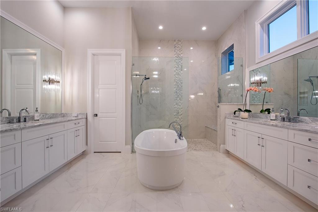 6830 Mangrove Avenue Naples, FL 34109 - Photo 17 of 28 a bathroom with a granite countertop sink a toilet a mirror and shower