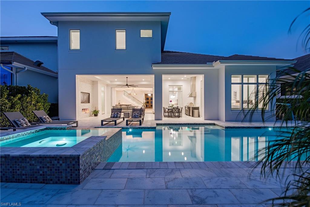 6830 Mangrove Avenue Naples, FL 34109 - Photo 2 of 28 a front view of a house with swimming pool patio and outdoor seating