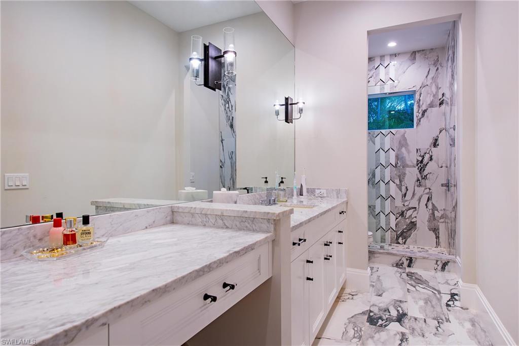 6830 Mangrove Avenue Naples, FL 34109 - Photo 22 of 28 a bathroom with a sink and a mirror