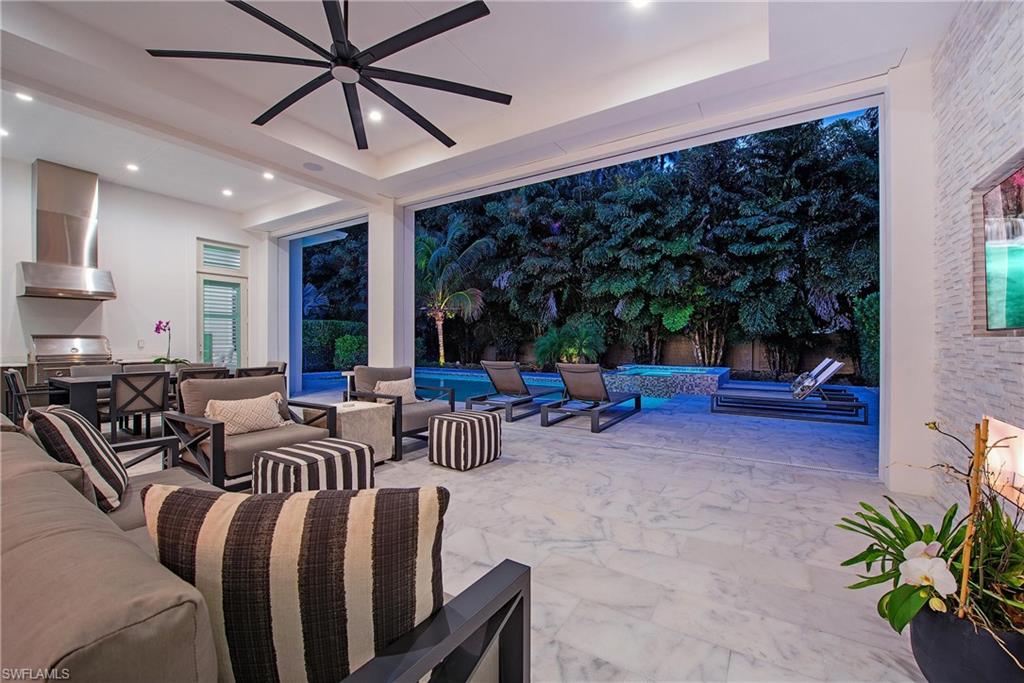 6830 Mangrove Avenue Naples, FL 34109 - Photo 10 of 28 a view of a patio with table and chairs potted plants with wooden floor