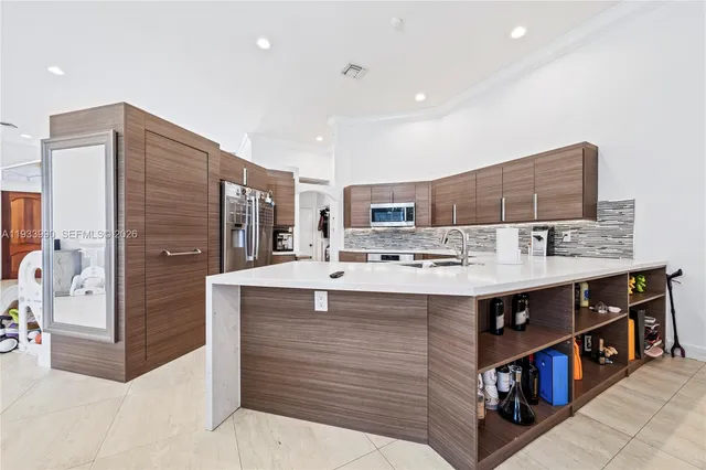 a large kitchen with kitchen island a sink stainless steel appliances and cabinets
