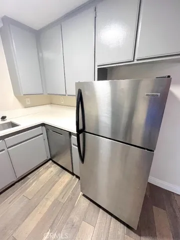 a view of a refrigerator in kitchen and an empty room
