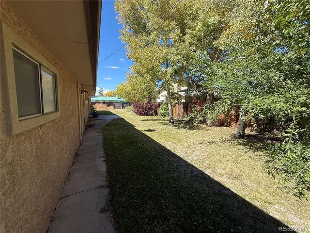 a view of a yard with wooden fence