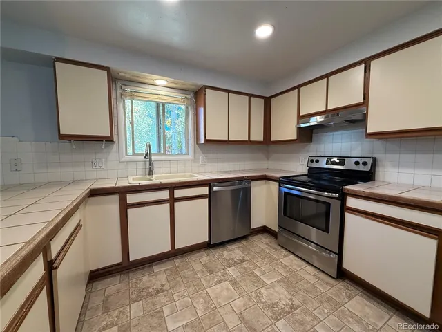 a kitchen with a sink stove and cabinets