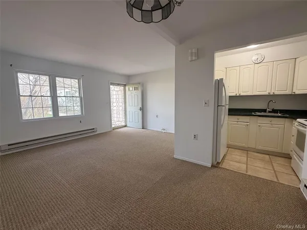 a kitchen with granite countertop white cabinets and white appliances