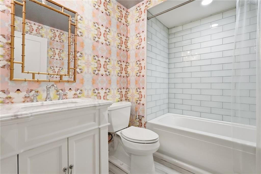 5742 Fifth Avenue, Unit 304 Pittsburgh, PA 15232 - Photo 28 of 32 a bathroom with a bathtub shower sink vanity mirror and toilet