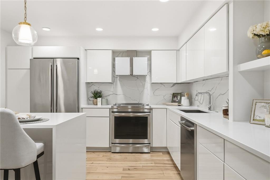 5742 Fifth Avenue, Unit 304 Pittsburgh, PA 15232 - Photo 4 of 32 a kitchen with stainless steel appliances granite countertop a sink stove and refrigerator