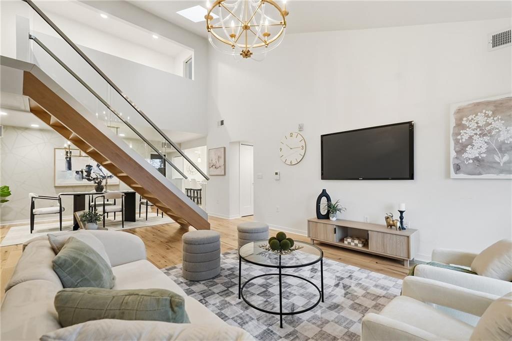 5742 Fifth Avenue, Unit 304 Pittsburgh, PA 15232 - Photo 10 of 32 a living room with furniture a flat screen tv and a chandelier