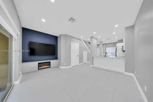 a view of a living room a flat screen tv and kitchen view