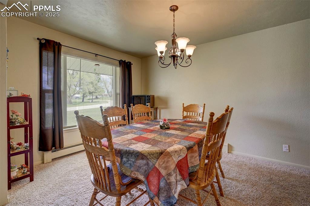 427 Ute Avenue Simla, CO 80835 - Photo 11 of 49 a view of a dining room with furniture a chandelier and wooden floor