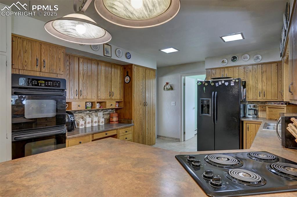 427 Ute Avenue Simla, CO 80835 - Photo 5 of 49 a kitchen with stainless steel appliances granite countertop a refrigerator a stove and a sink with wooden cabinets