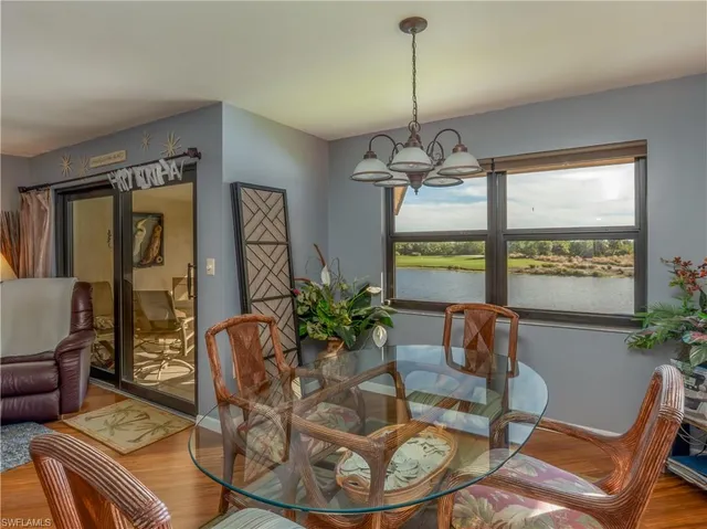 a dining room with furniture a chandelier and wooden floor