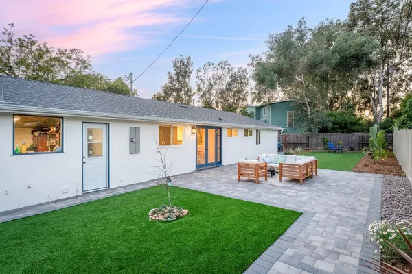 a view of a house with backyard sitting area and garden