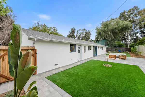 a backyard with a table and chairs and a barbeque