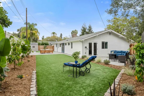 a view of a house with backyard sitting area and garden