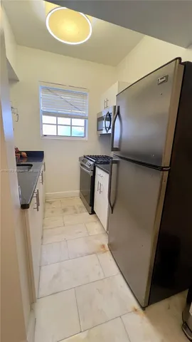 a kitchen with stainless steel appliances granite countertop a sink and a refrigerator