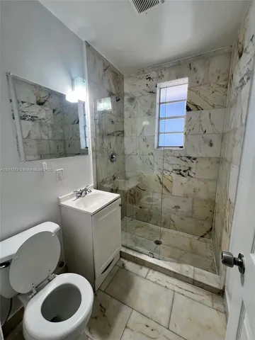a bathroom with a toilet sink and shower