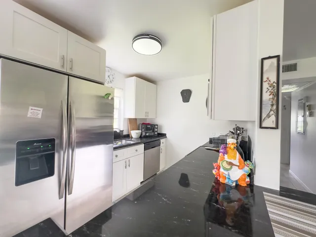 a kitchen with stainless steel appliances granite countertop a refrigerator and a stove