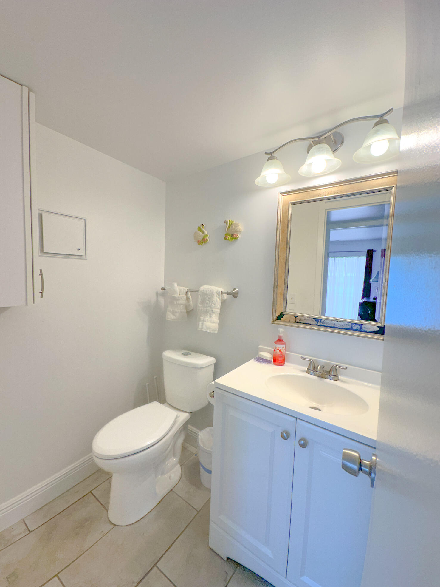 127 Mansfield D Boca Raton, FL 33434 - Photo 18 of 27 a bathroom with a toilet sink vanity and mirror