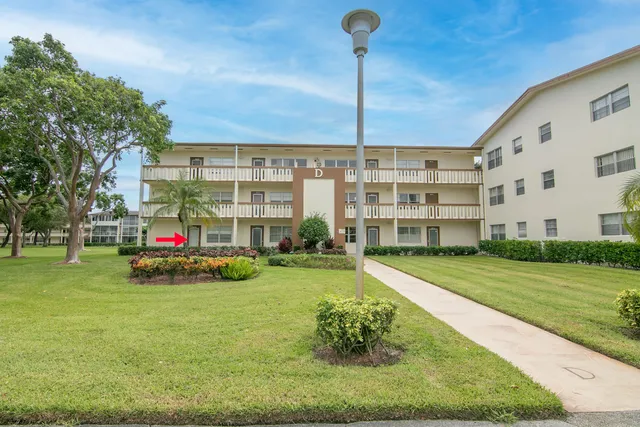 a view of a house with a big yard and large trees