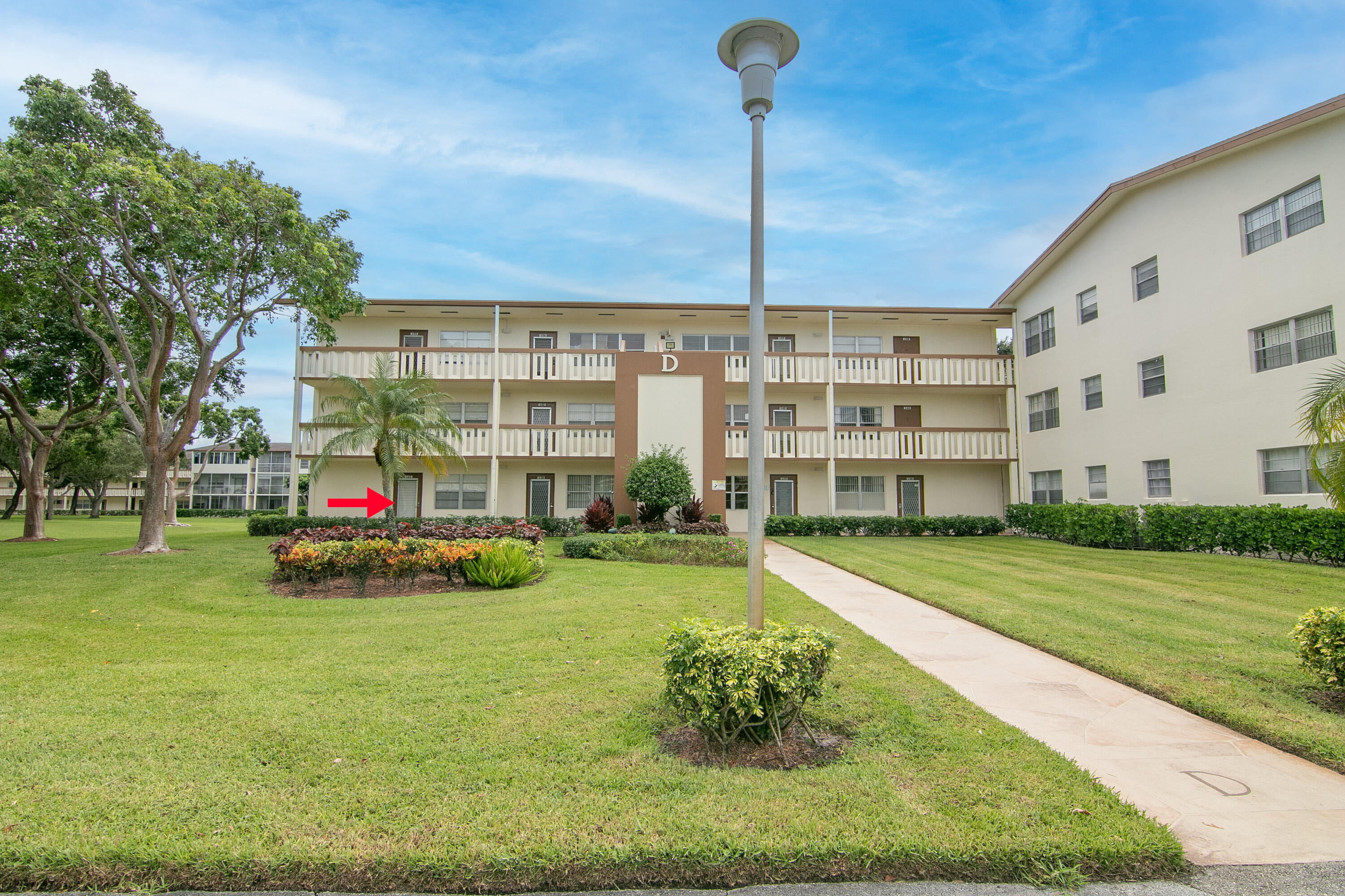 127 Mansfield D Boca Raton, FL 33434 - Photo 25 of 27 a view of a house with a big yard and large trees