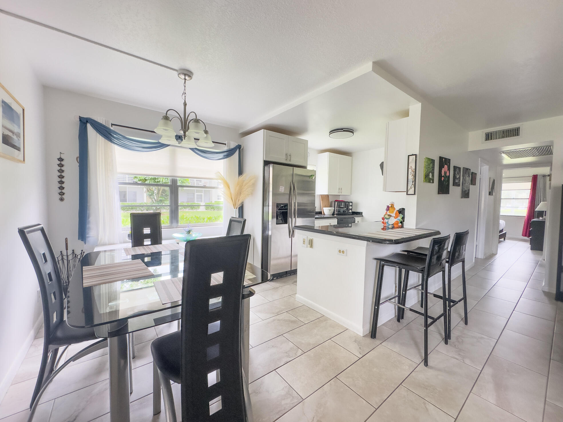 127 Mansfield D Boca Raton, FL 33434 - Photo 4 of 27 a kitchen with stainless steel appliances kitchen island granite countertop a dining table chairs and granite counter tops