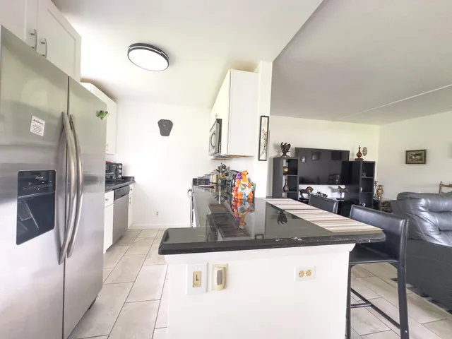 a kitchen with stainless steel appliances granite countertop a sink a stove and refrigerator