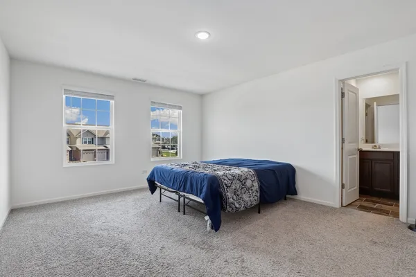 a spacious bedroom with a bed and a window
