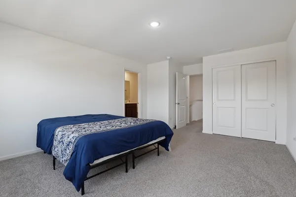 a spacious bedroom with a bed and a cabinets