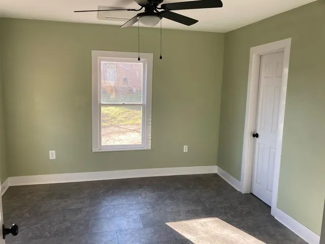 a view of a room with a window and a ceiling fan