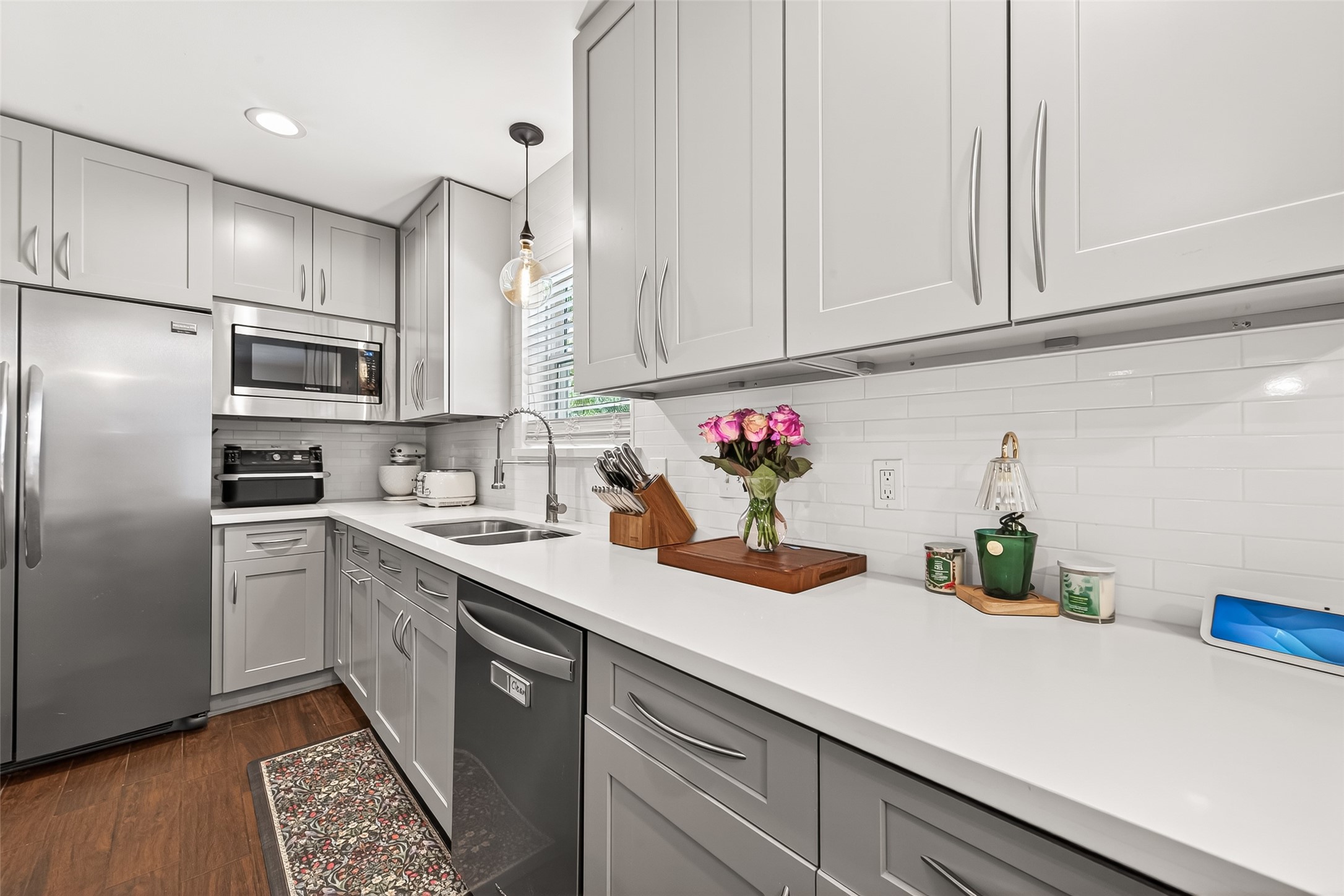 2610 Teague Road Houston, TX 77080 - Photo 28 of 49 This kitchen features sleek gray cabinetry, stainless steel appliances, and a bright white subway tile backsplash. The space is modern and well-lit, with ample counter space and a clean, contemporary design.