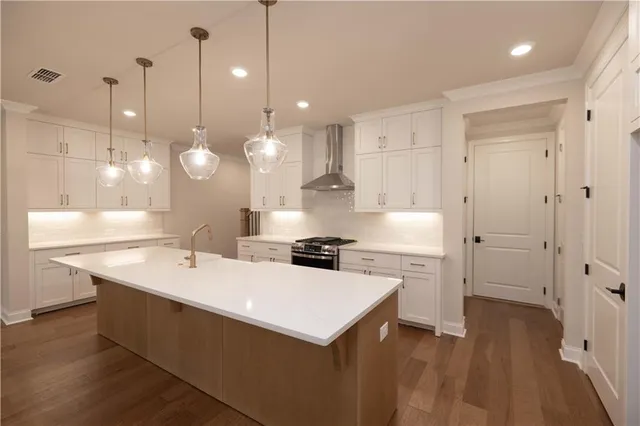 a kitchen with a sink a stove a refrigerator and white cabinets