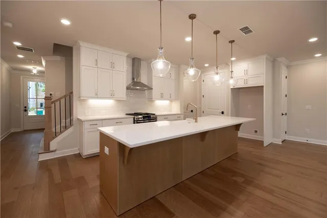 a large kitchen with kitchen island a sink stainless steel appliances and a chandelier